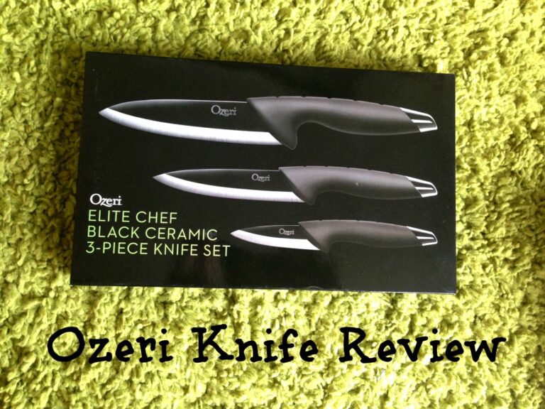 A black box displaying the Ozeri Elite Chef Ceramic Knife Set sits on a green textured surface. Text at the bottom reads Ozeri Knife Review in a playful font.