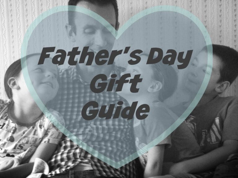 A black-and-white photo of a father and three children framed by a large blue heart. Overlaid text reads, Father’s Day Gift Guide. They are smiling and sitting closely together—perfect inspiration for Father’s Day gifts.