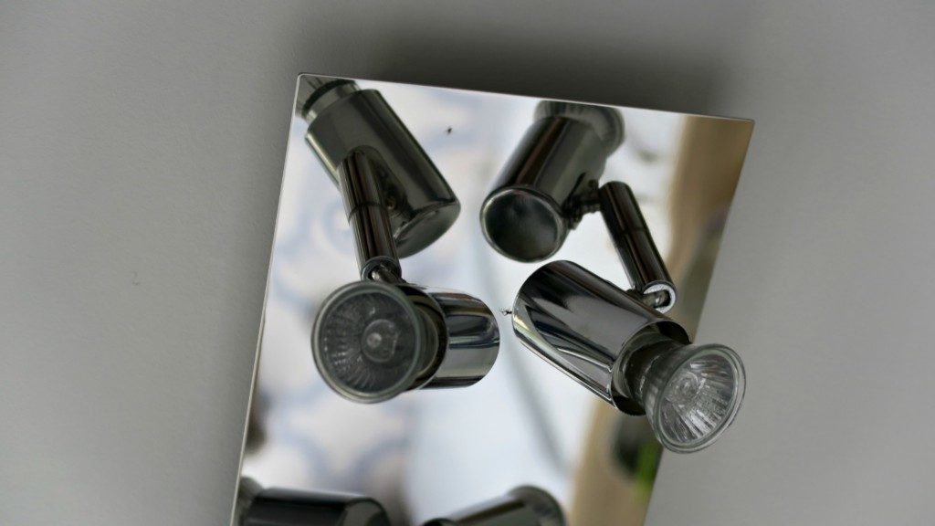 A close-up view of a modern ceiling light fitting with two adjustable spotlight bulbs on a reflective rectangular metal base, perfect for enhancing your kitchen lighting.