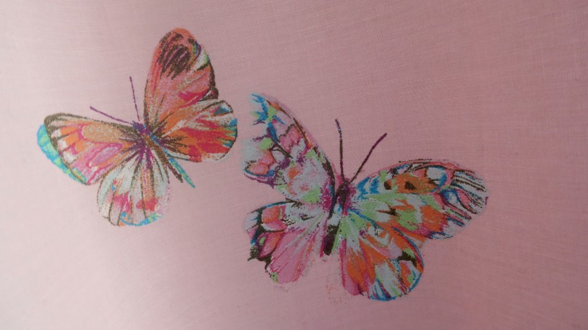 Two colourful, artistic butterflies with multicoloured wings are illustrated on a light pink fabric background, perfect for brightening up a twin girls' bedroom.