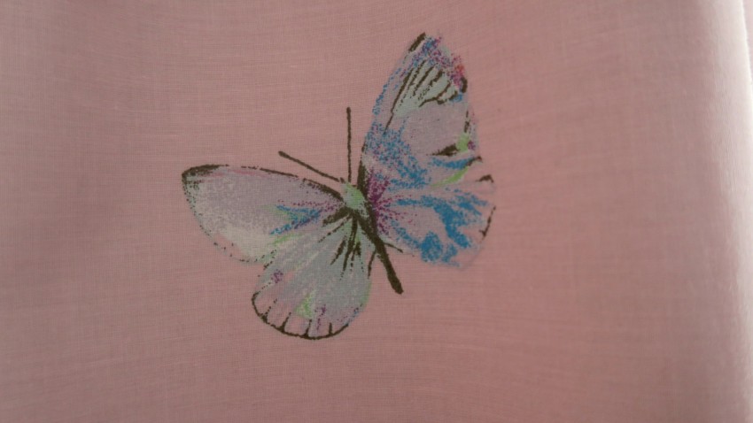 A pastel-coloured butterfly illustration with blue, pink, and green tones is printed on a soft, light pink fabric background—perfect for adding a sweet touch to a Twin Girls' Bedroom.