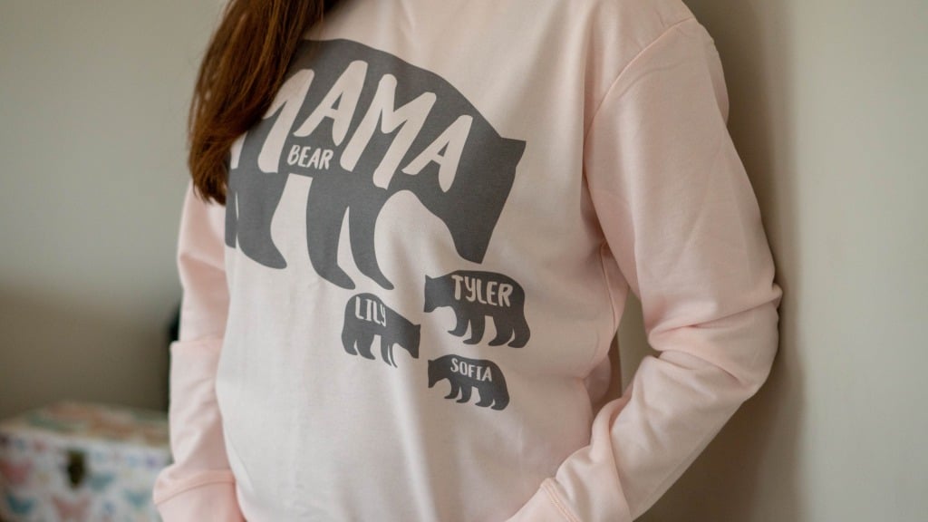 A person wearing a pale pink Mama Bear sweatshirt with three small bears labelled Lily, Tyler, and Sofia stands against a neutral background—an adorable pick for any 2020 Mother’s Day Gift Guide.