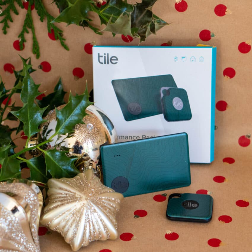 Tile tracker set displayed in front of its box, with two trackers visible. Surrounded by festive Christmas decorations, it's the perfect addition to your gift guide for must-have home tech and thoughtful Christmas presents.