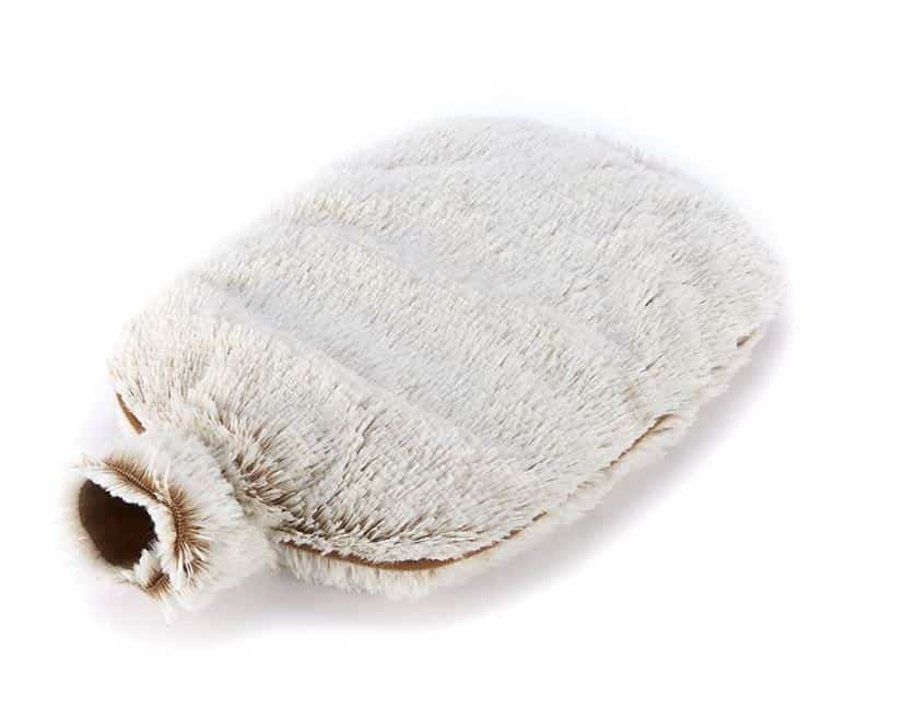 A beige, furry hot water bottle with a soft, plush cover is shown lying on a white background—perfect to warm up your bedroom and add cosy comfort for autumn and winter nights.
