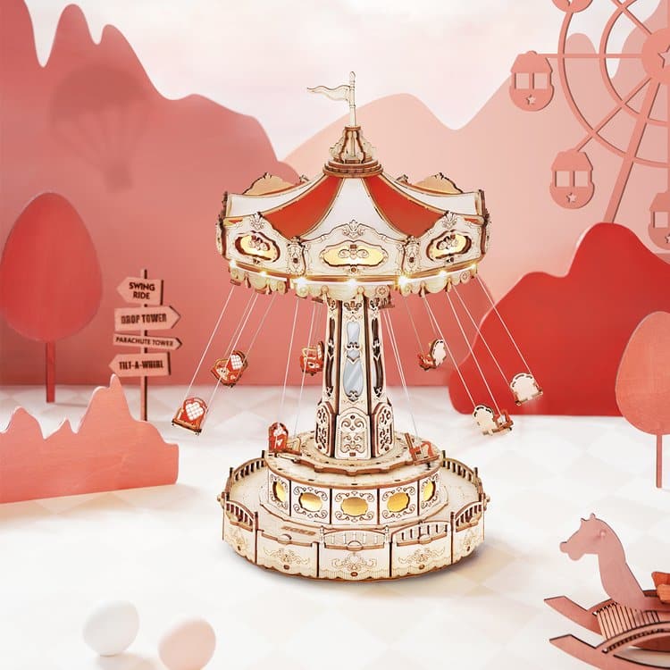A decorative carousel model with small animal seats hangs from chains, set in a whimsical, red-and-pink themed landscape featuring stylised trees, a ferris wheel, playful signs, and a stylish puzzle element in the background.